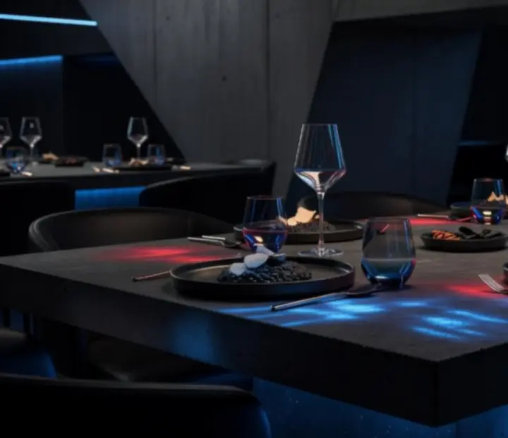 Zárt körű, elegánsan megterített privát vacsoraasztal futurisztikus belső térben.
